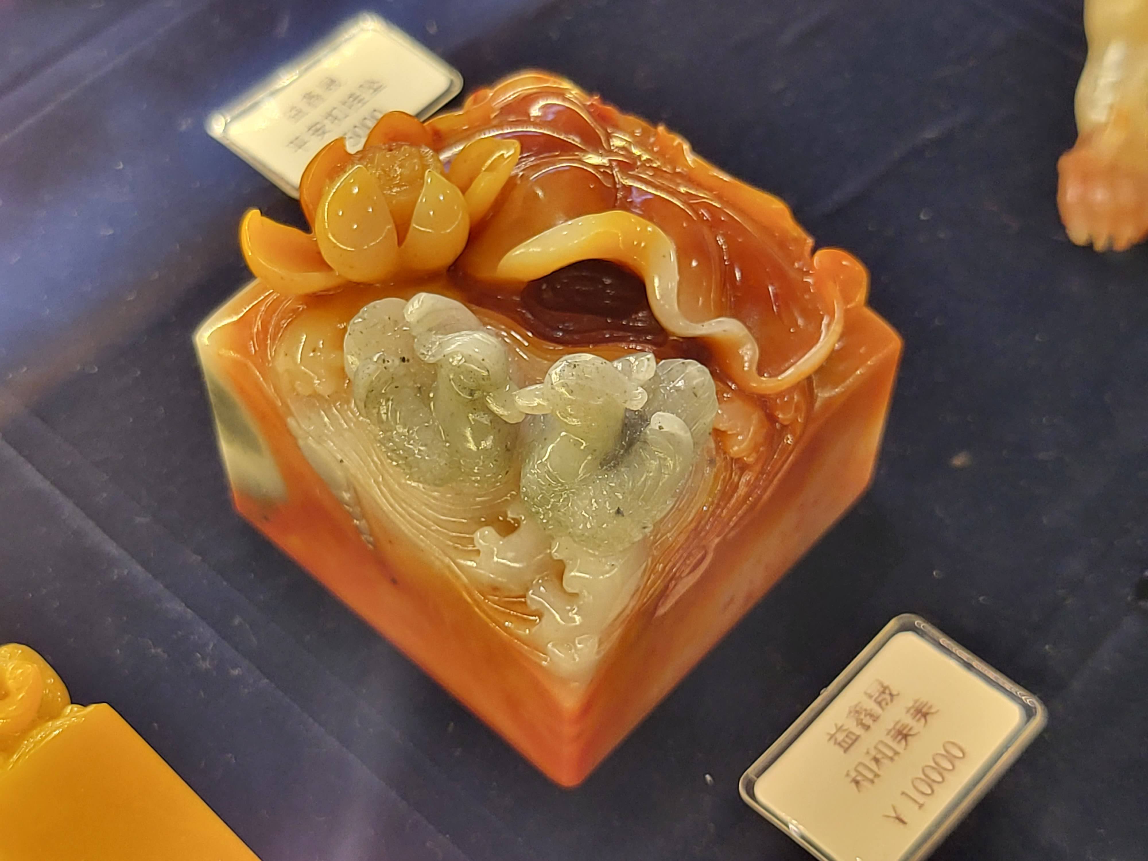 A polished multicolored stone carving with rounded forms.