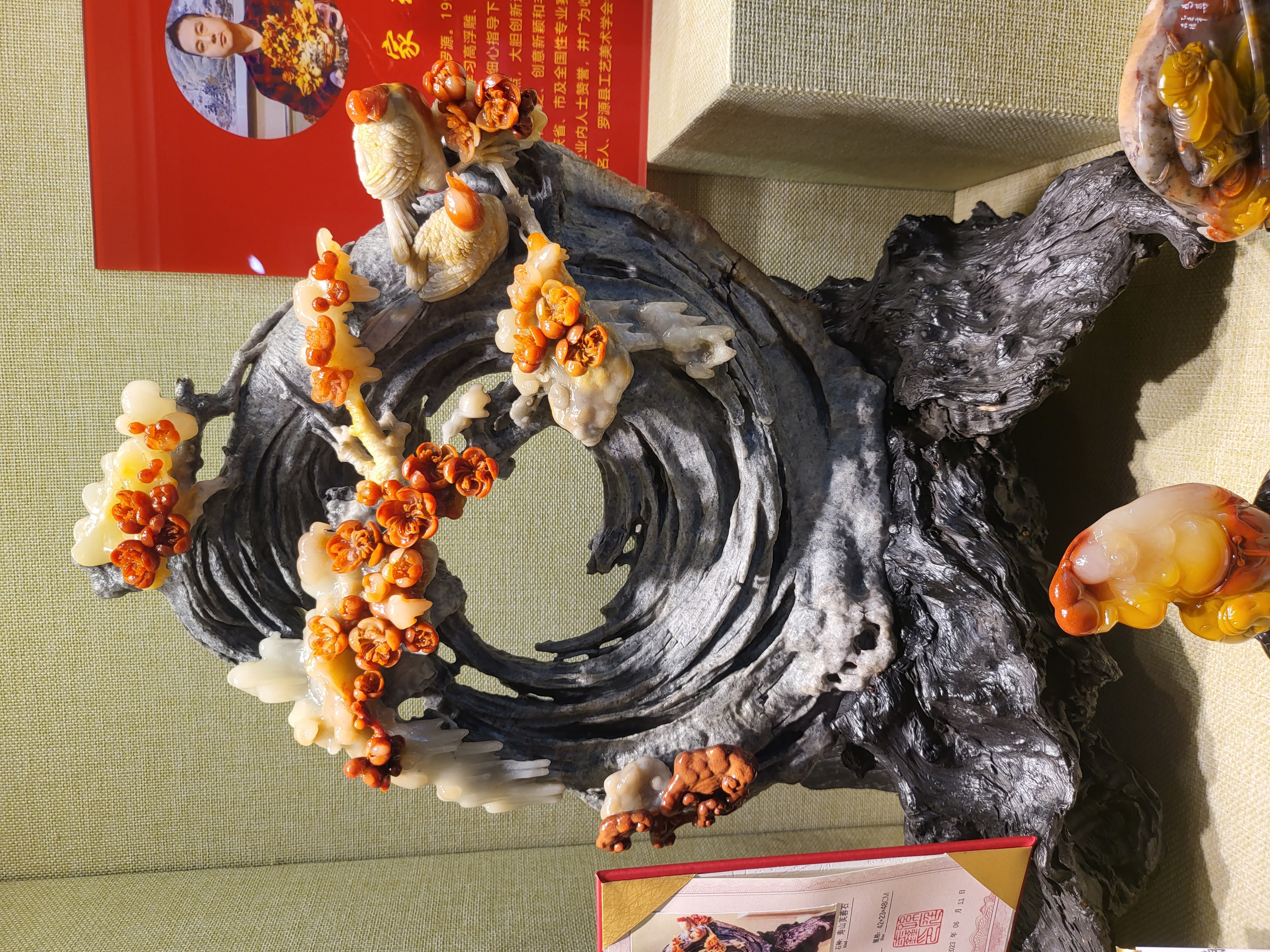 A dark sculptural base beneath branching ornament.