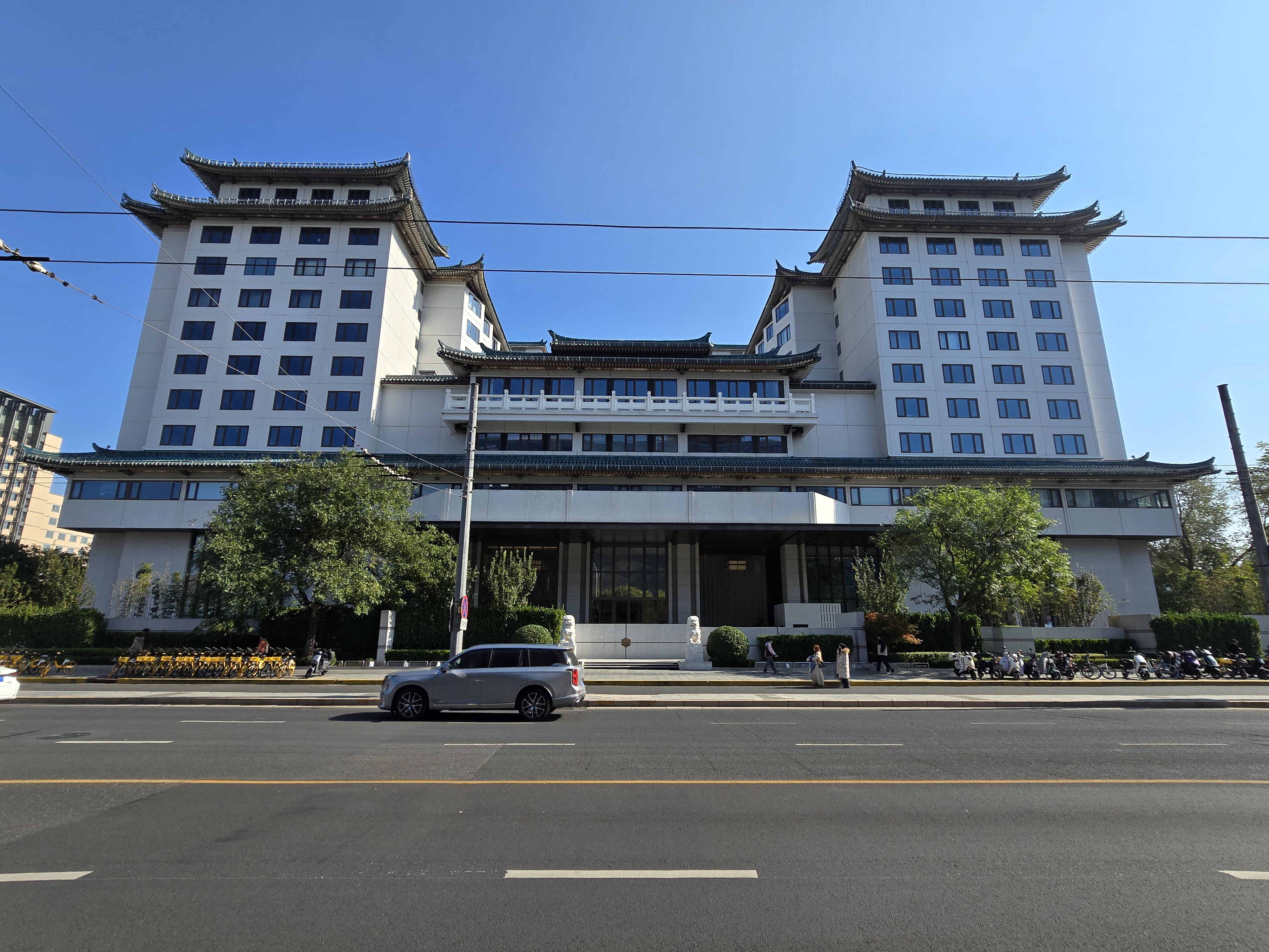 A symmetrical building with two towers crowned by traditional roofs.