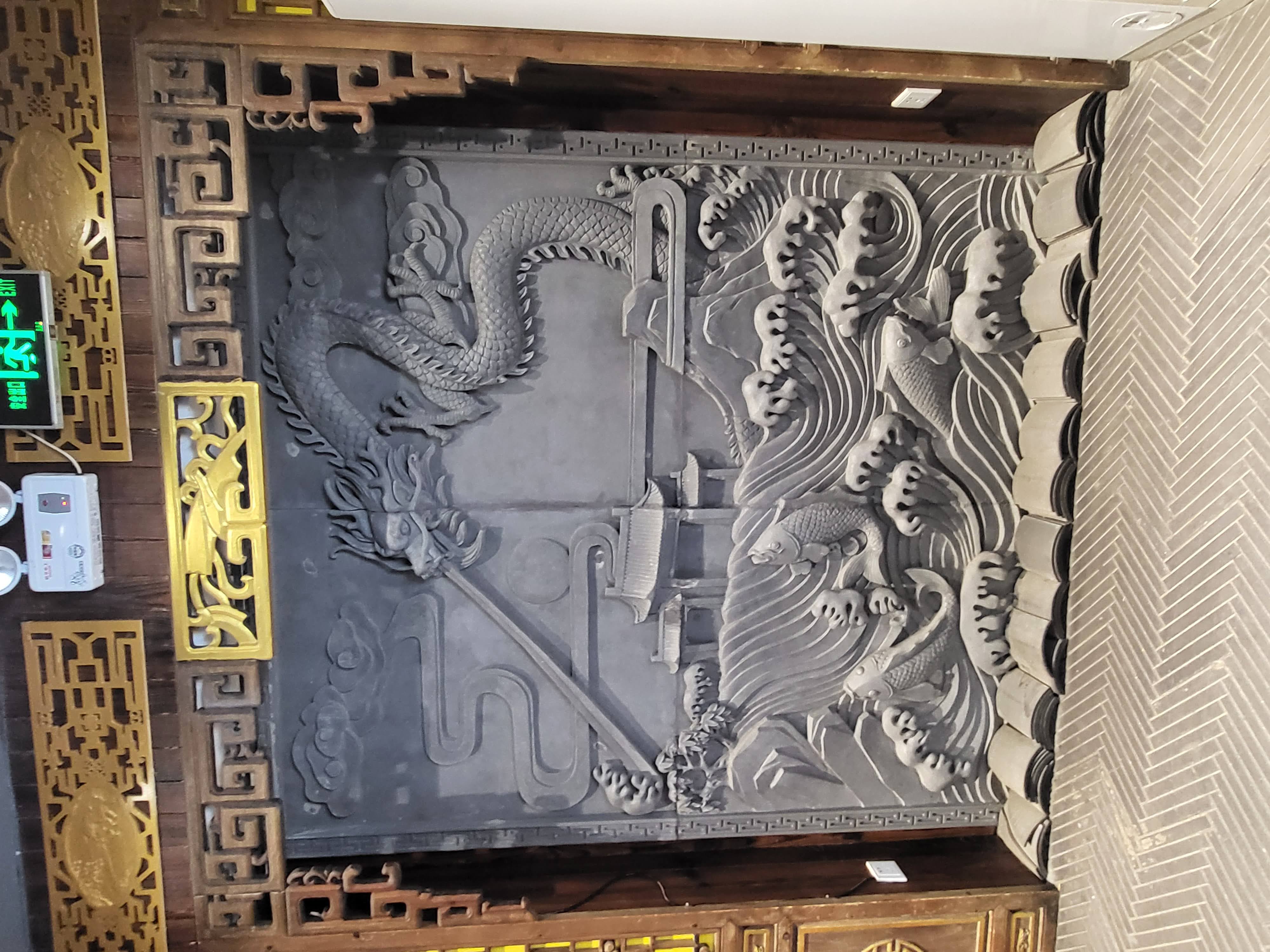 A dragon relief fills a decorative screen.