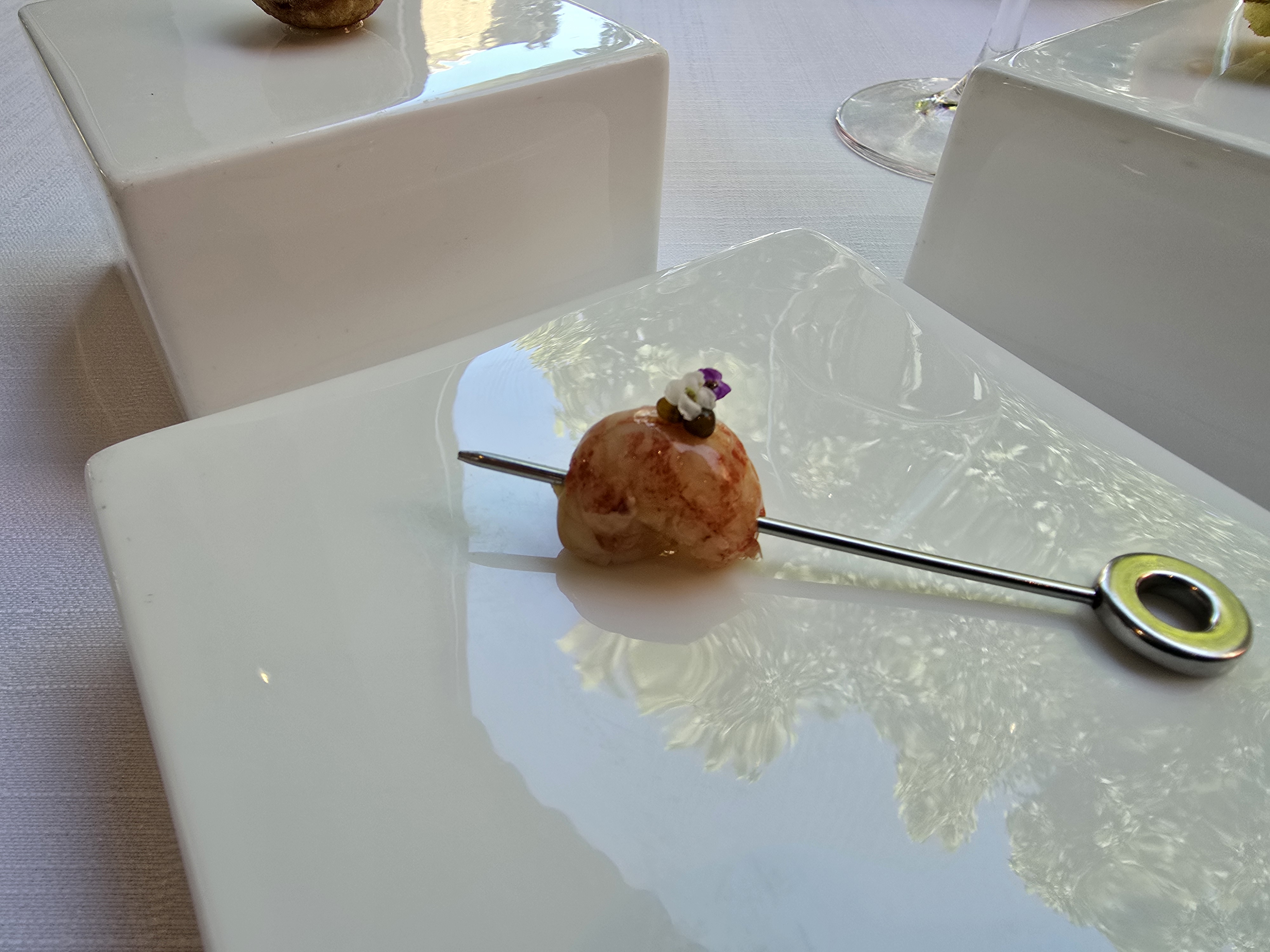 A golden bite served on a small spoon.