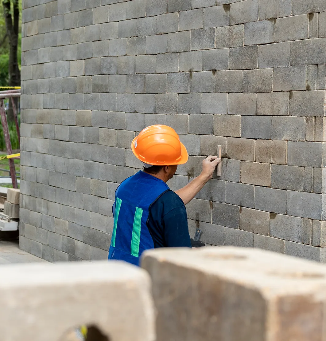 Man adding grout to a brick wall