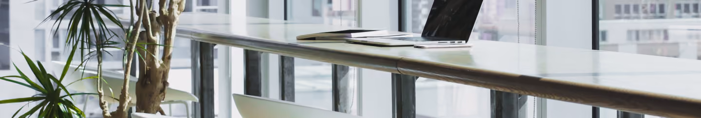 Laptop on a glass table in a bright modern office