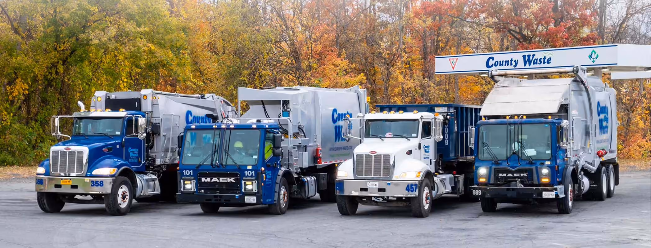 Fleet of County Waste garbage trucks parked in a row