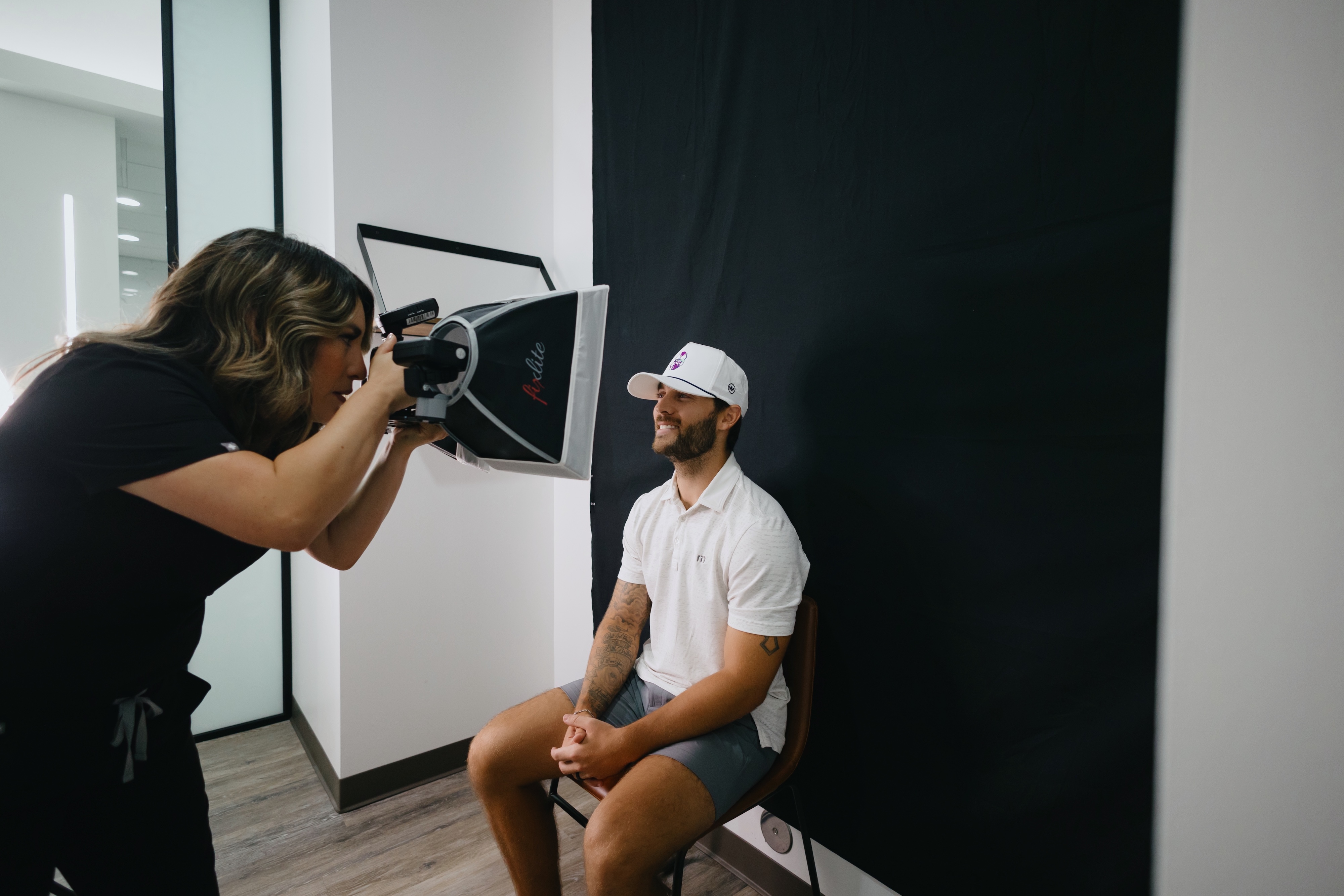 Dental patient smiling for the camera while the dentist takes photos to capture the dental patients veneers process