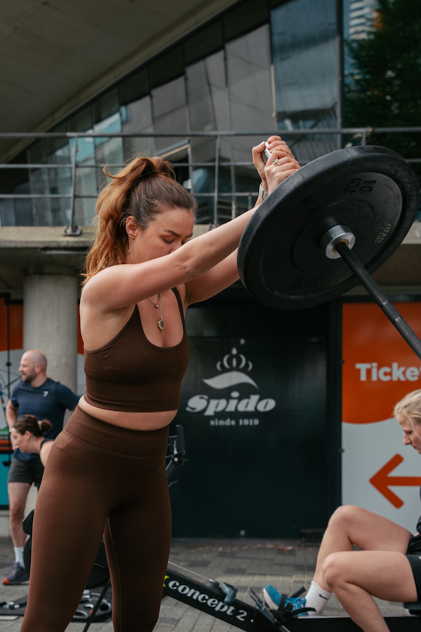 Vrouw doet shoulder press tijdens een workout