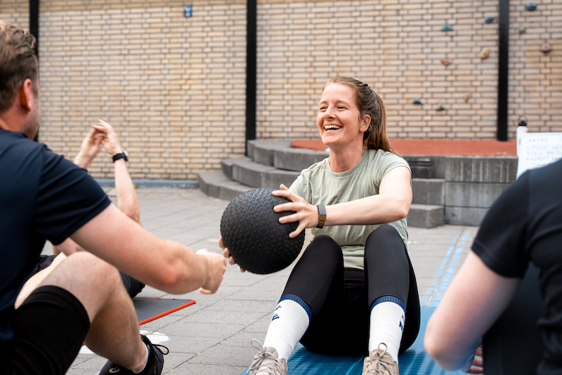Vrouw doet een buikoefening tijdens de bootcamp