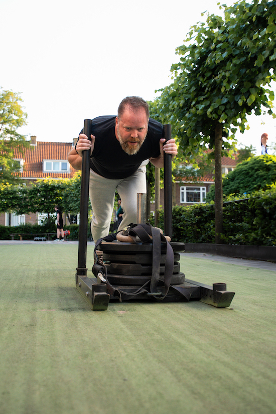 Man doet een sled push tijdens een bootcamp training