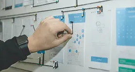 Una mano tocando un tablero que contiene un plan estratégico.