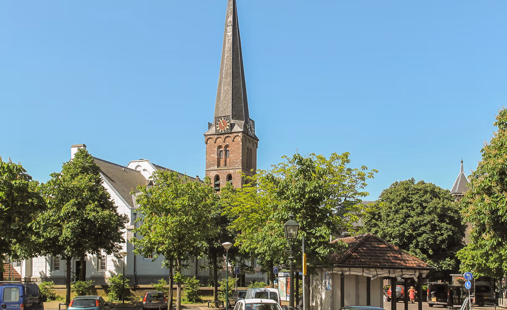 Kerkplein met bomen en karakteristieke kerktoren in Baarn.