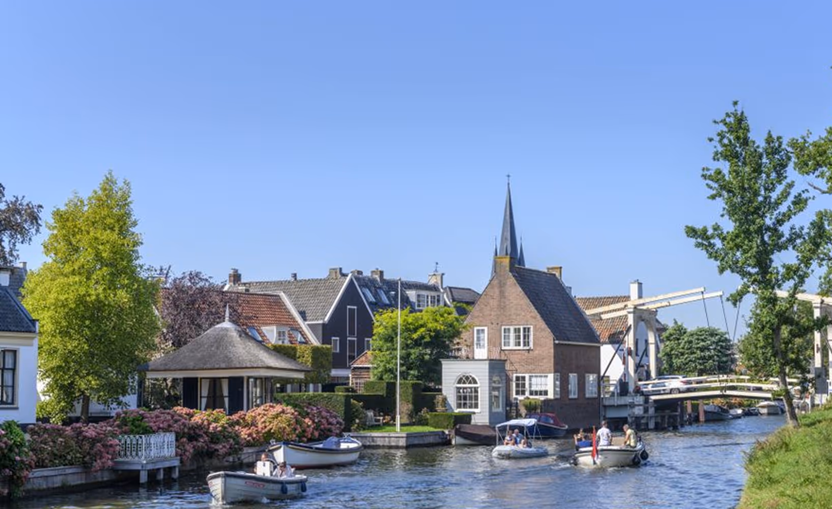 Dorpsgezicht aan het water met brug, boten en historische huizen in Breukelen.