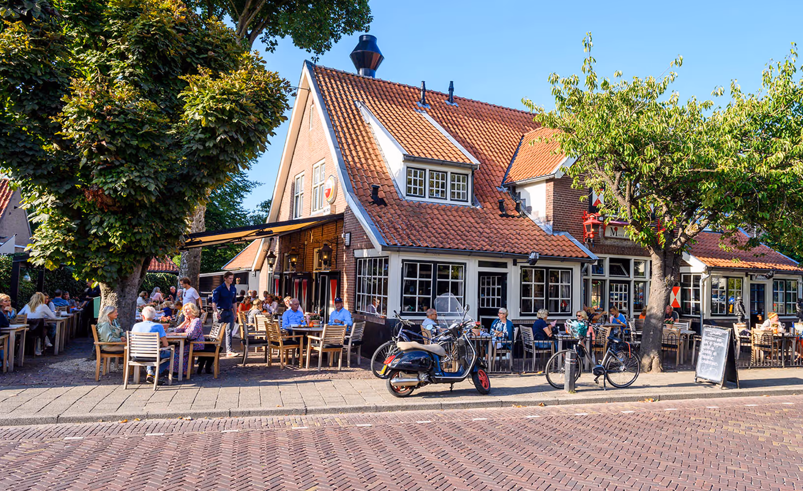 Gezellig terras met fietsers en horecagelegenheden in het centrum van Blaricum.