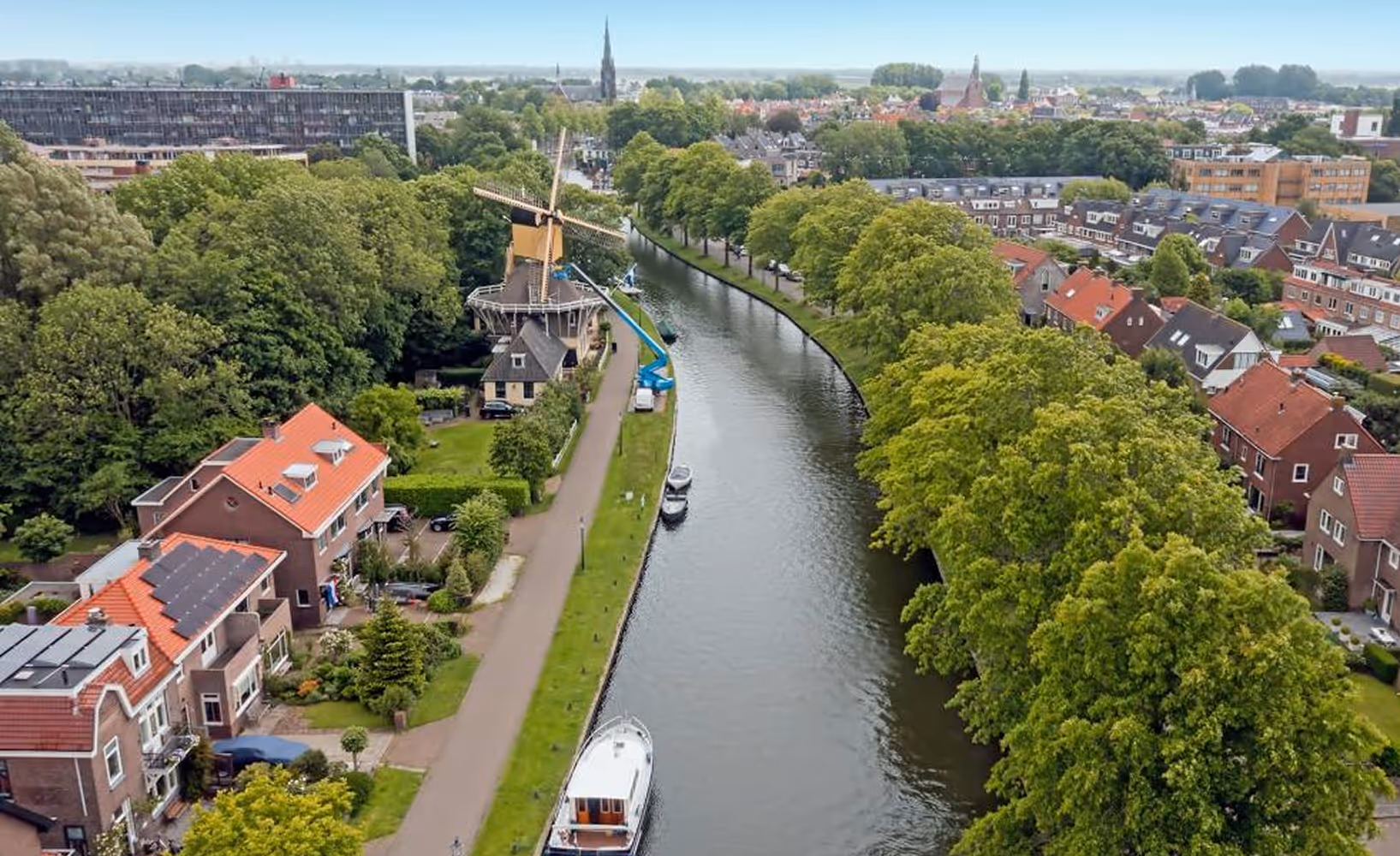 Luchtfoto van Weesp met molen, kanaal en woonhuizen langs het water.