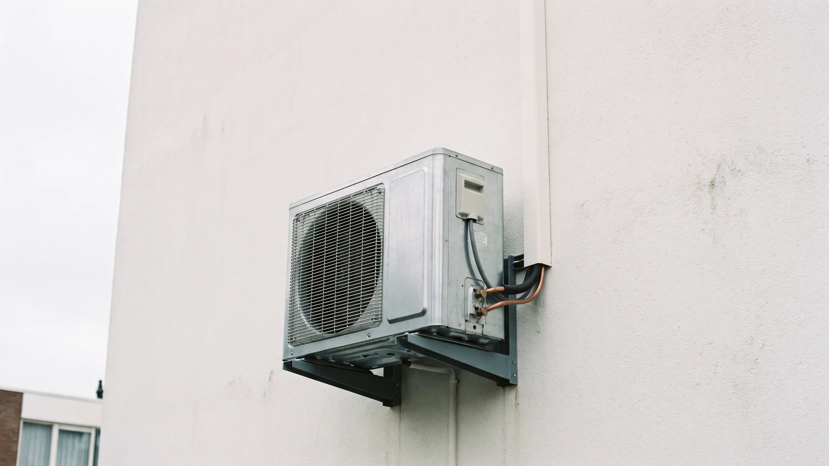 Multi split buitenunit gemonteerd op een witte gevel met koperen leidingen netjes weggewerkt