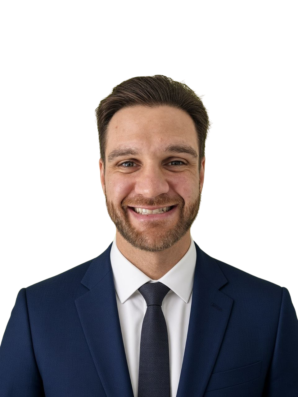 Smiling man with brown hair and beard wearing a dark blue suit, white shirt, and dark blue tie against a transparent background.