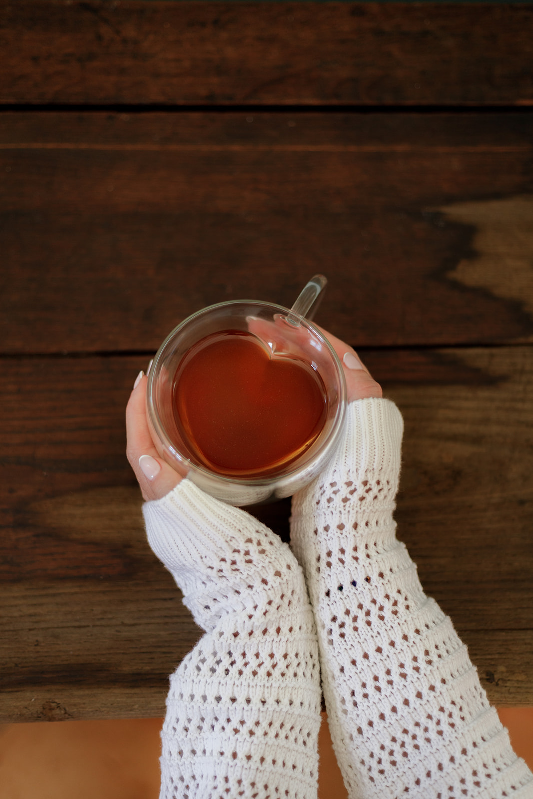 Mains tenant une tasse d'infusion Cacaothé en forme de cœur