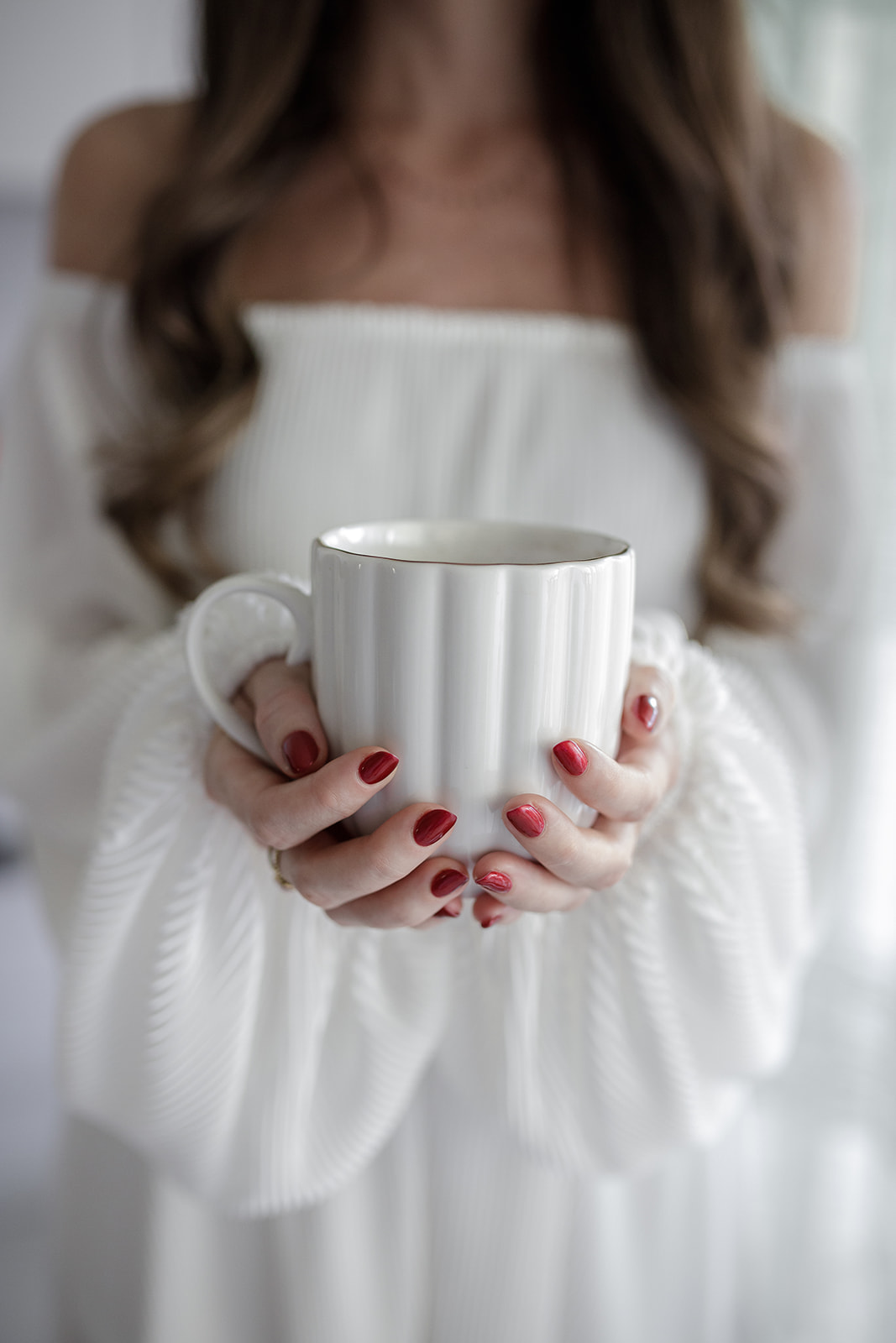Mains tenant une tasse blanche d'infusion Cacaothé