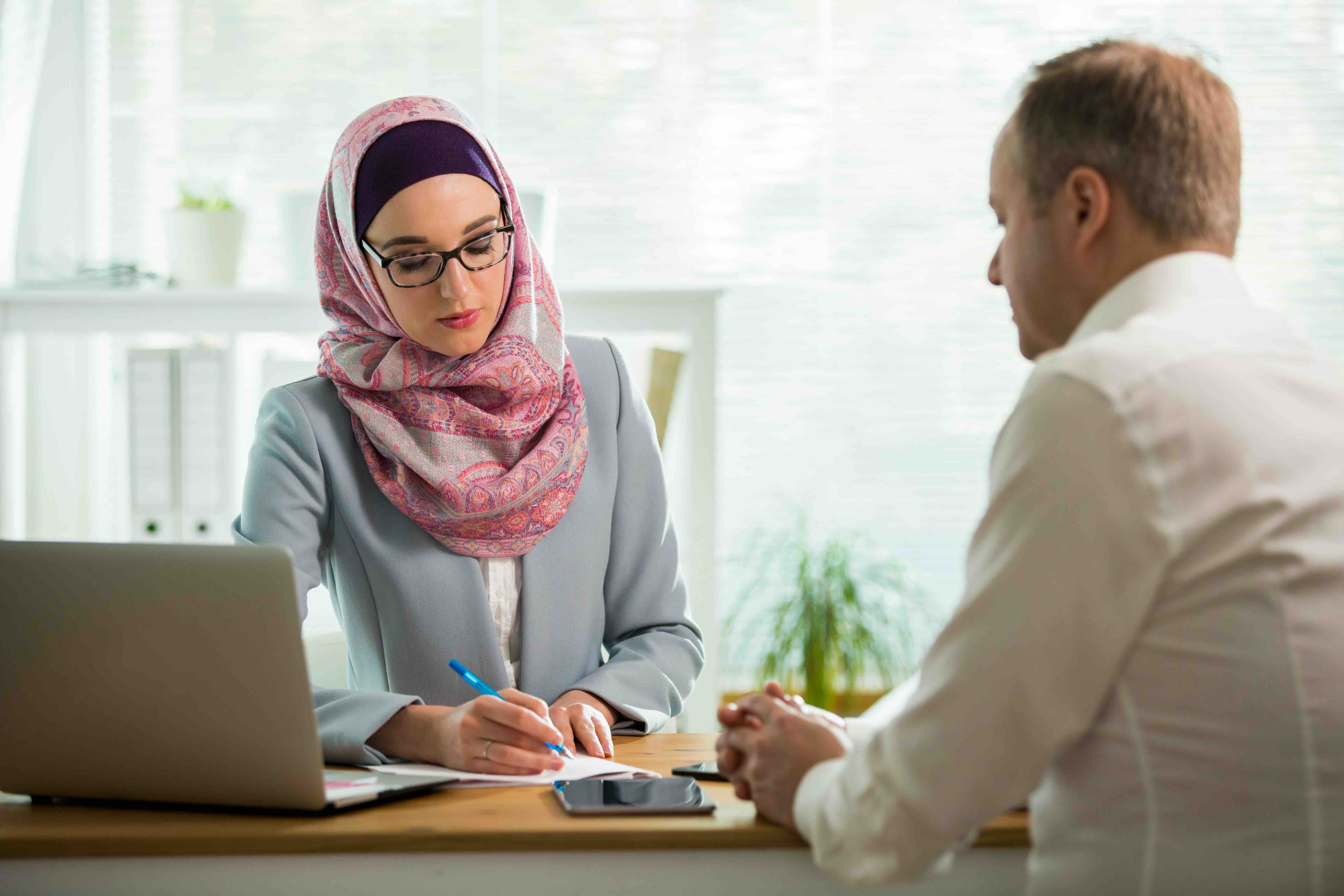 Une femme derrière son ordinateur qui discute avec un homme |Monceau Langues