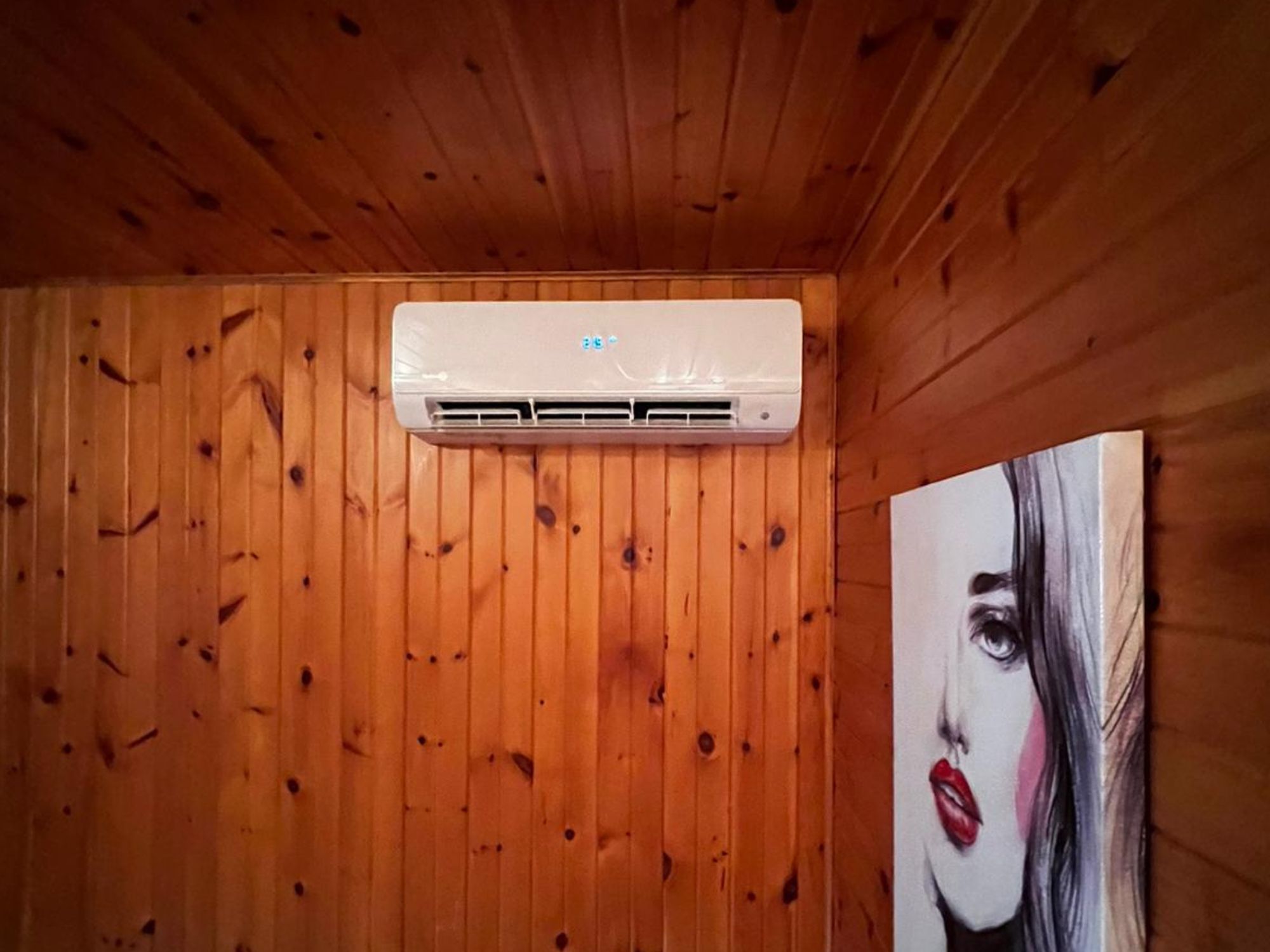 Tête de thermopompe installée sur le mur d'un salon
