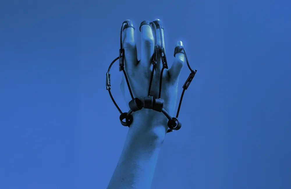 A hand wearing a wired motion-tracking glove, raised against a blue background