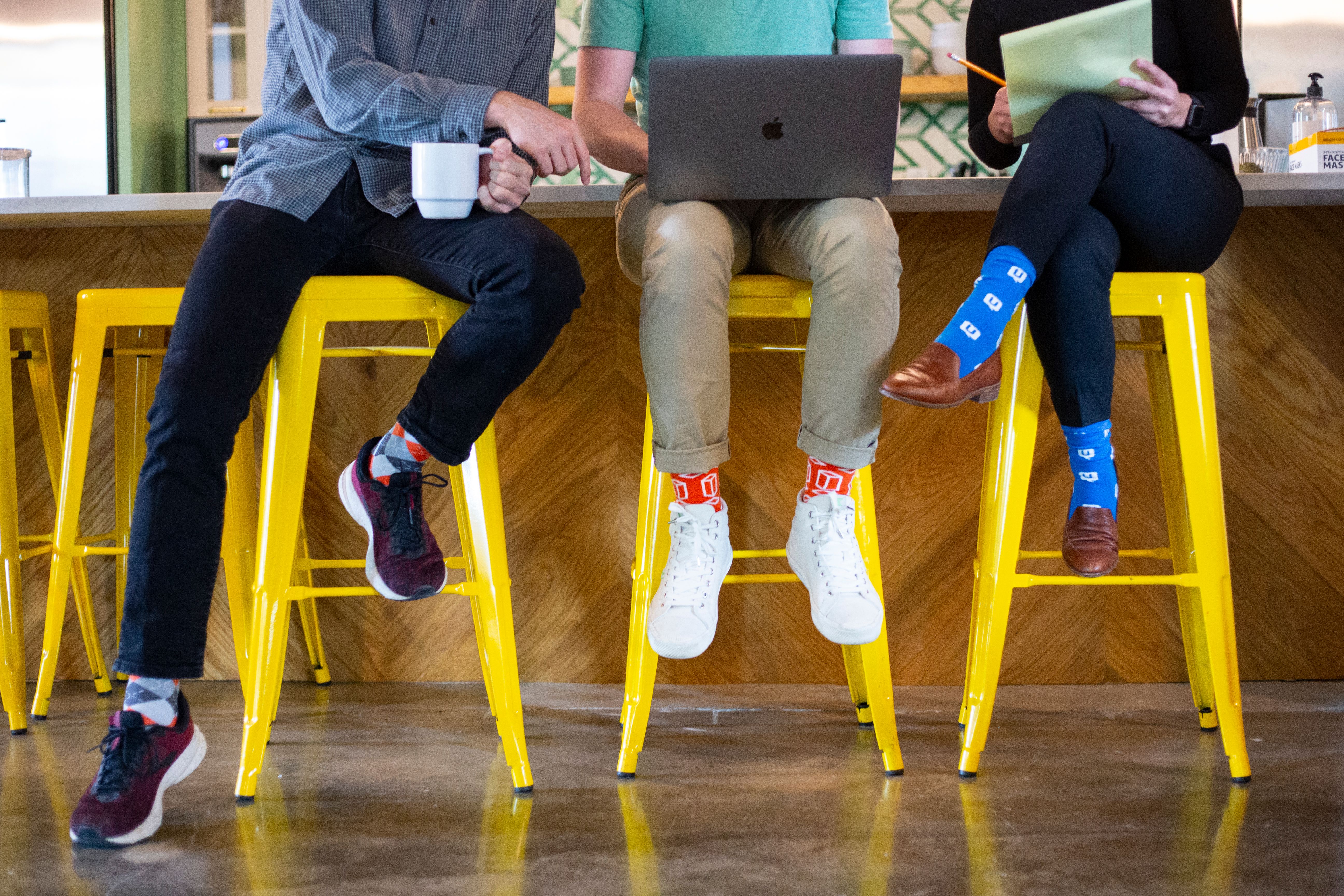 Team members wearing custom designed socks in modern office environment
