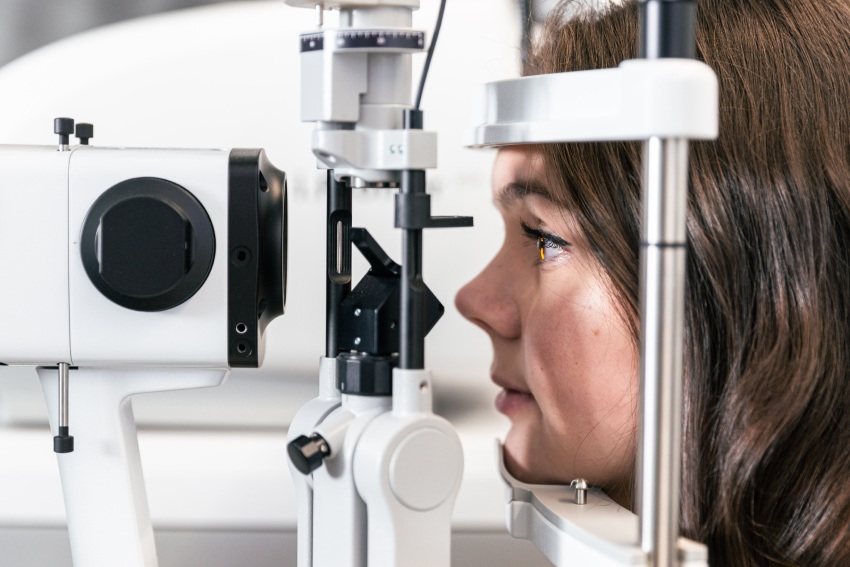 Optometrist assessing a patient for dry eye disease using a slit lamp microscope