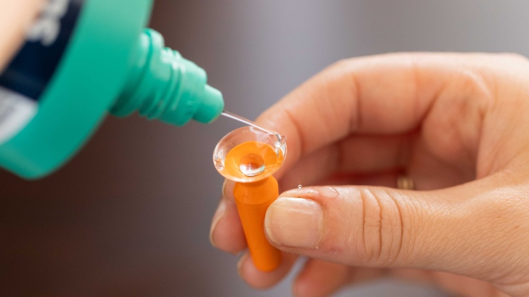 Scleral contact lens being filled with preservative-free saline before insertion