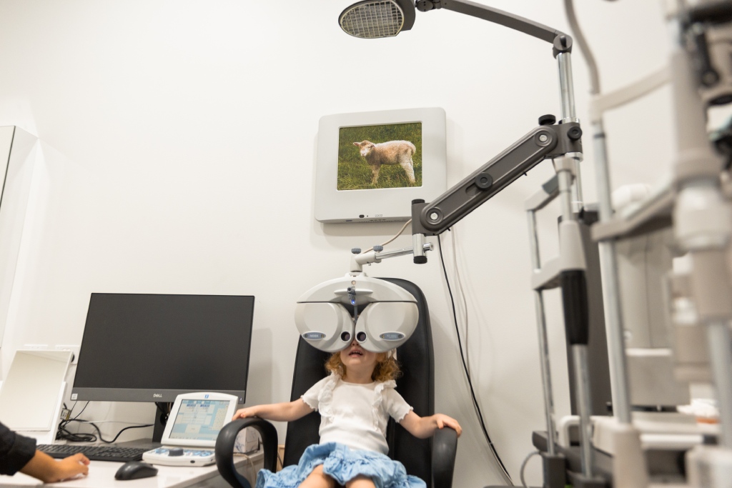 Young child completing a myopia assessment with an optometrist using specialised vision testing equipment