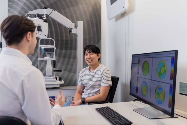 Optometrist discussing meibomian gland dysfunction assessment results with a patient
