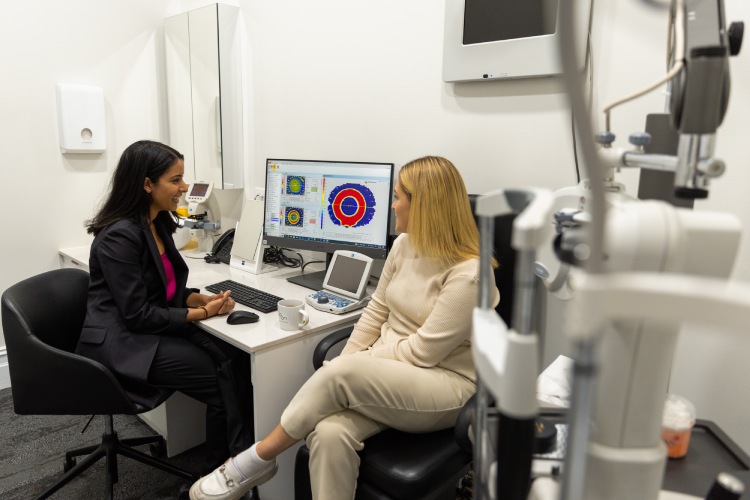 Optometrist discussing corneal topography results during a first morning Ortho-K review