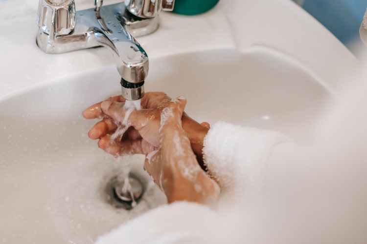 Person washing their hands before handling Ortho-K contact lenses