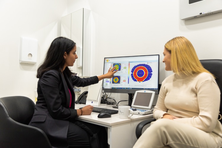 Optometrist discussing corneal topography results during an Ortho-K suitability assessment