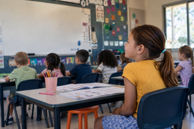 Child sitting in a classroom, illustrating how a lazy eye can affect learning and school activities