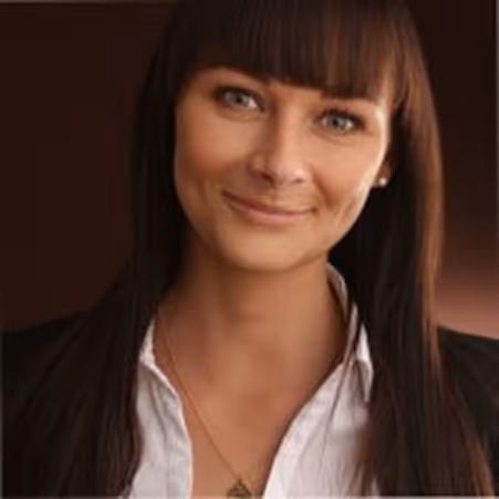 Porträt von Esther Eitel mit langen braunen Haaren und Pony vor dunklem Hintergrund.