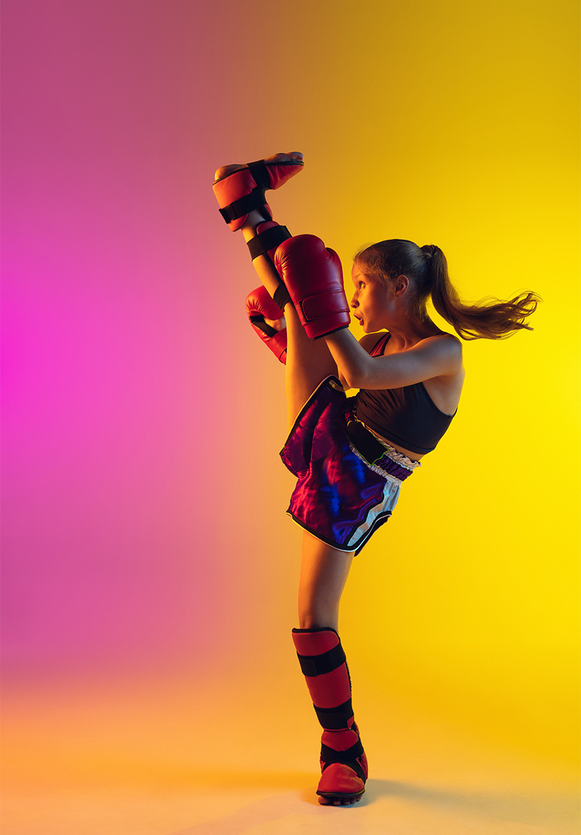 A young athletic girl boxing against a fluorescent background. 