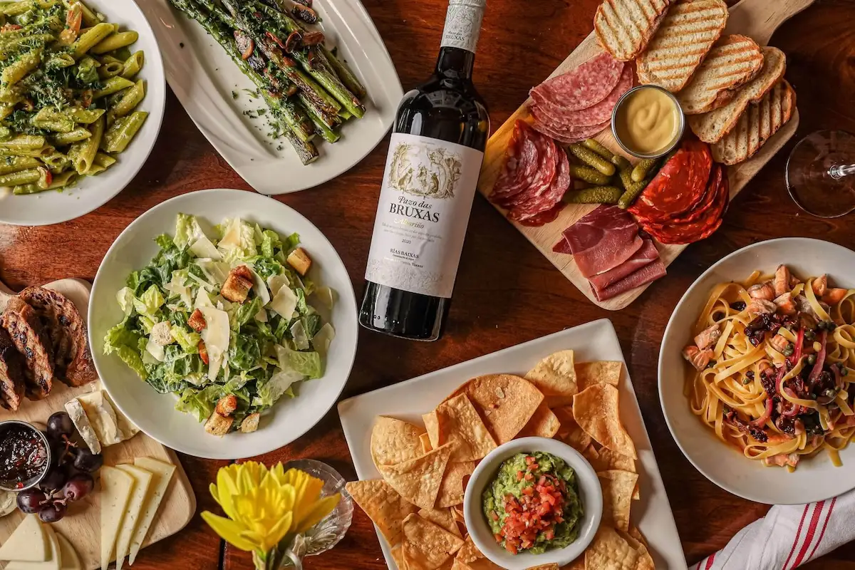 Birds eye view of spread of dinner items and a wine bottle on table