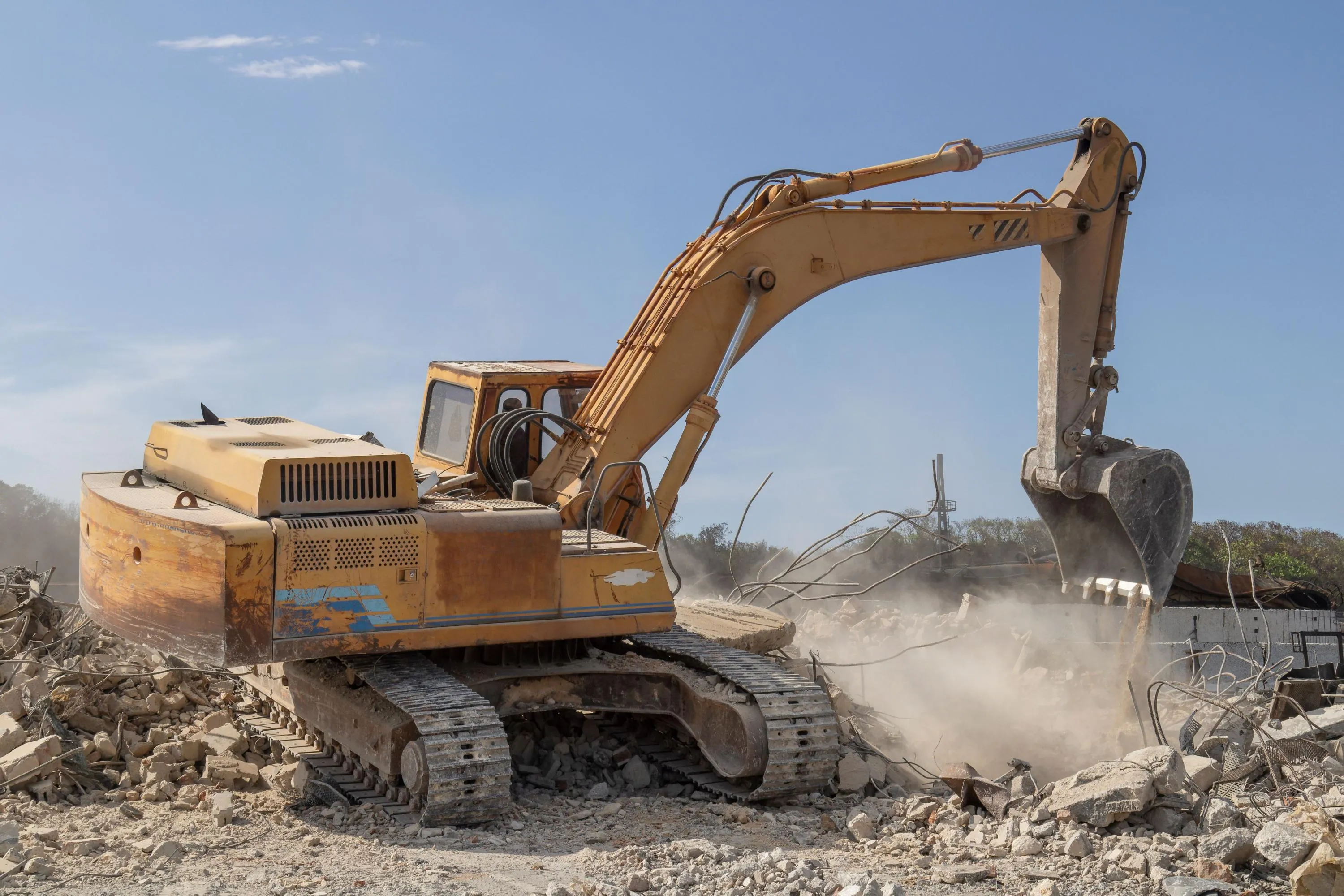 excavator loading rubble into a dump truck