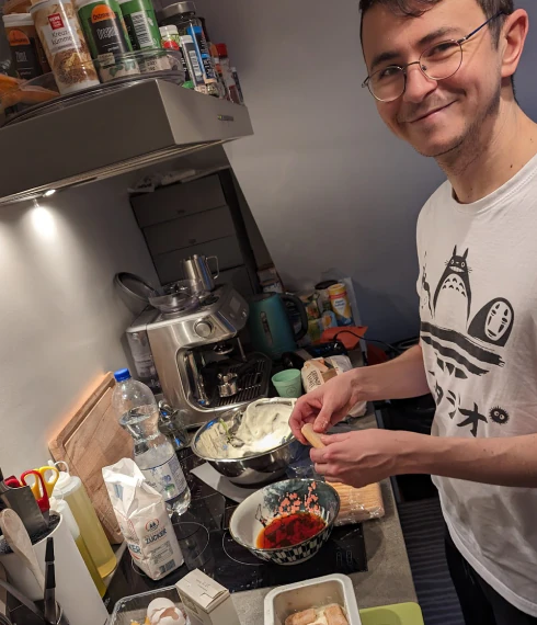 A Konpo team member smiling while cooking in a home kitchen