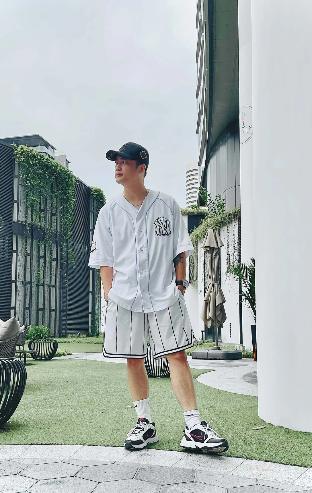 Kenny from the Konpo team in a white baseball jersey on a rooftop terrace