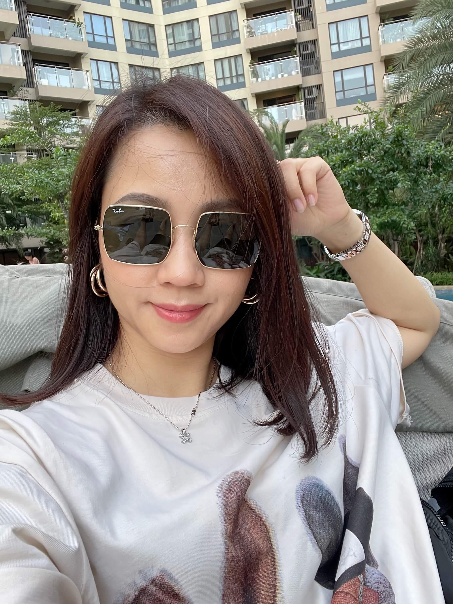 Minh Thu from the Konpo team taking a selfie in sunglasses by a pool