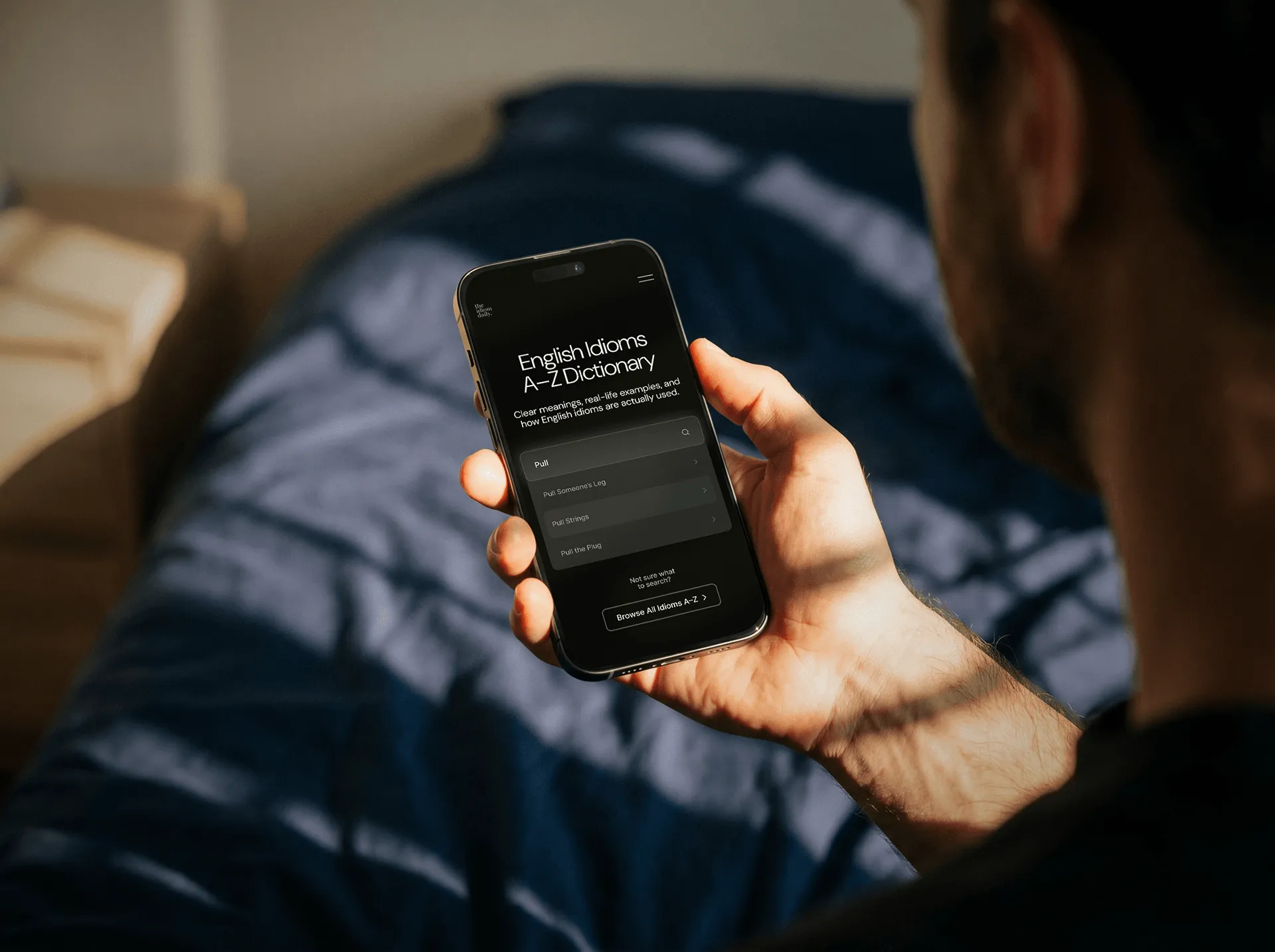Man viewing TID English idioms dictionary on a phone