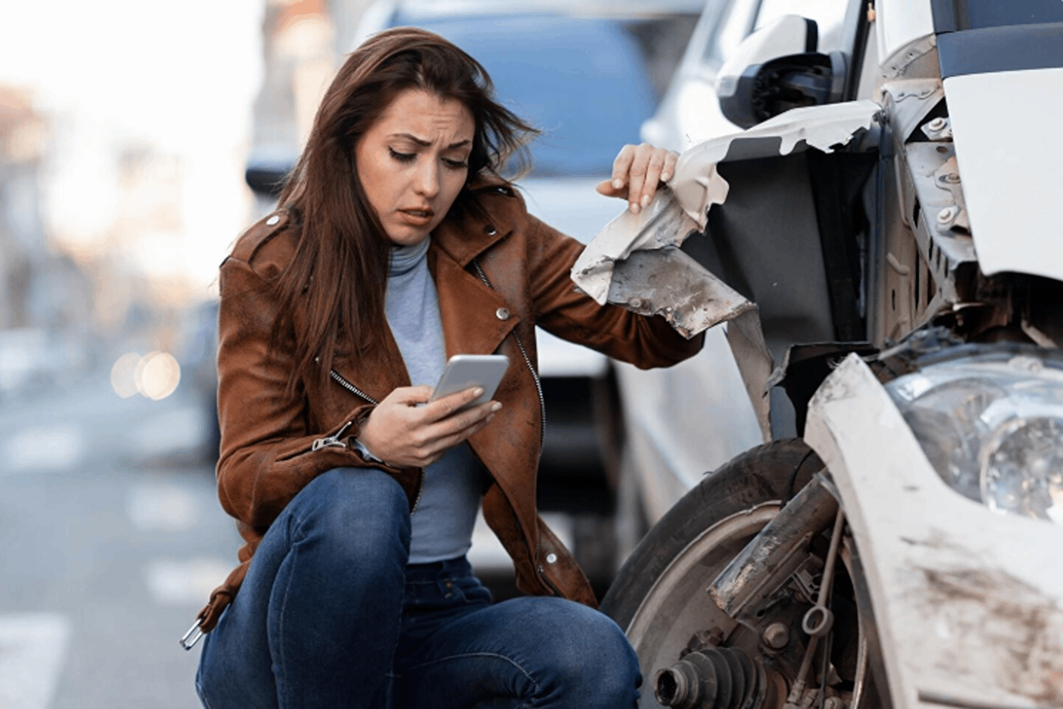A woman contacting a car collision center after damage.