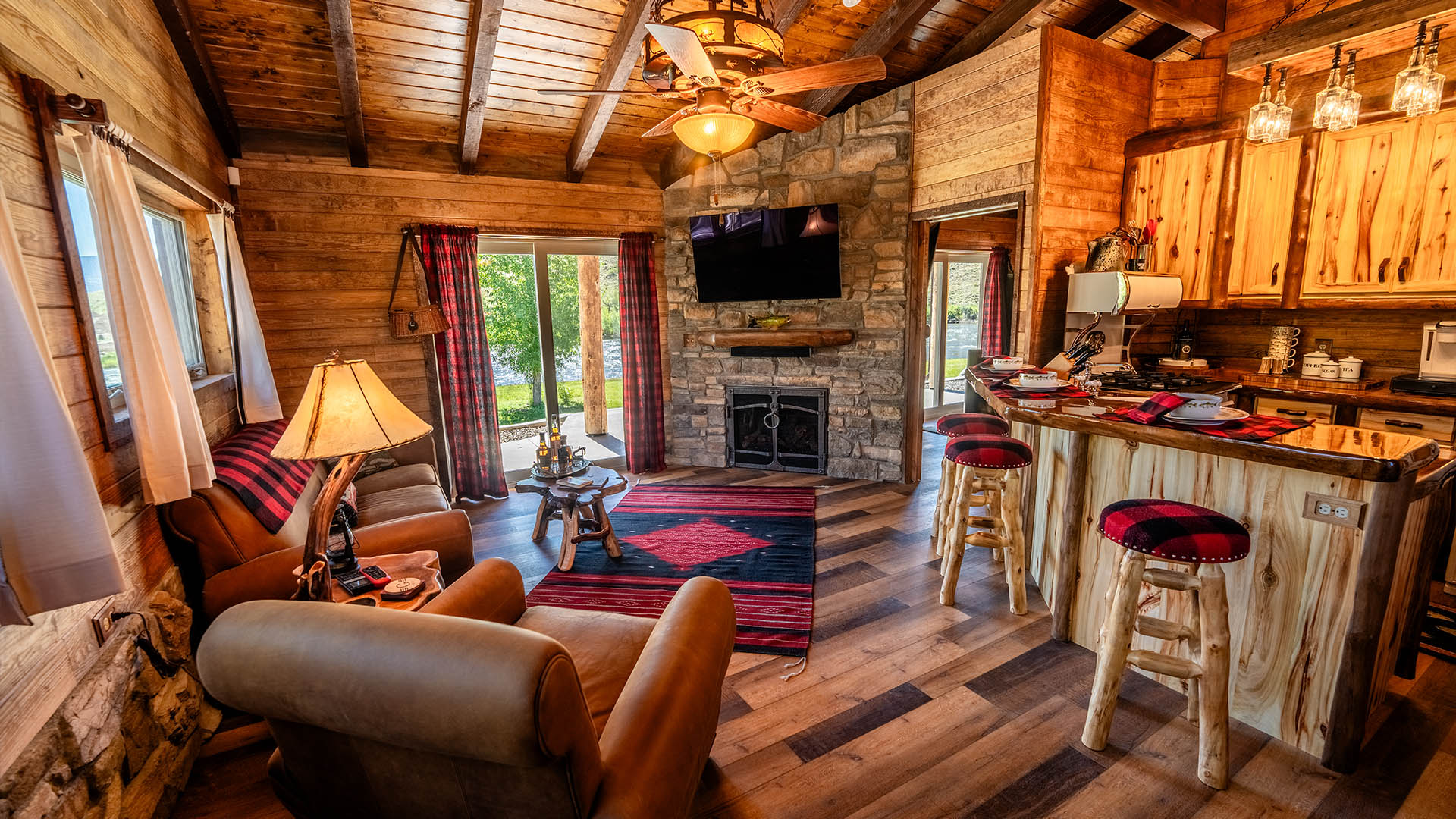 Cabin living room with stone fireplace and kitchen bar