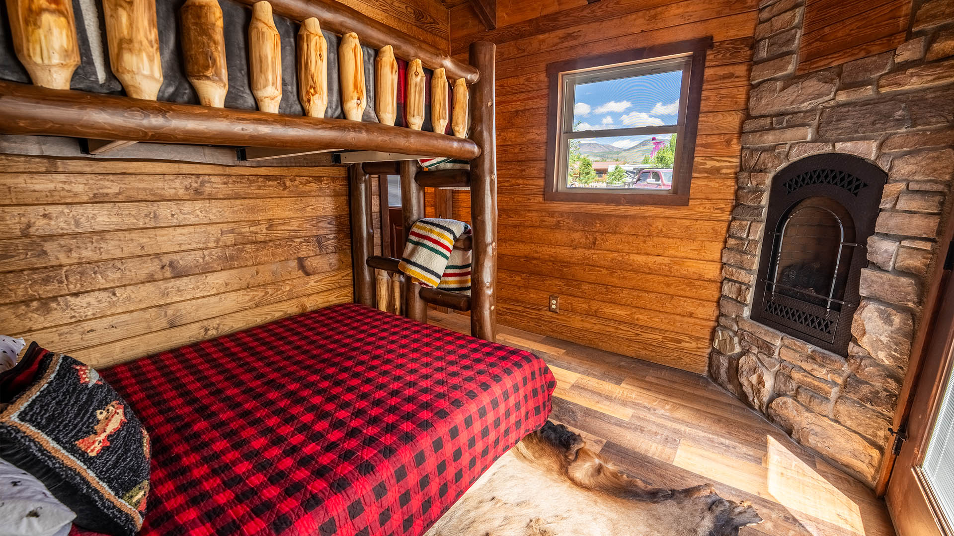 Cabin bedroom with log bunk beds and fireplace