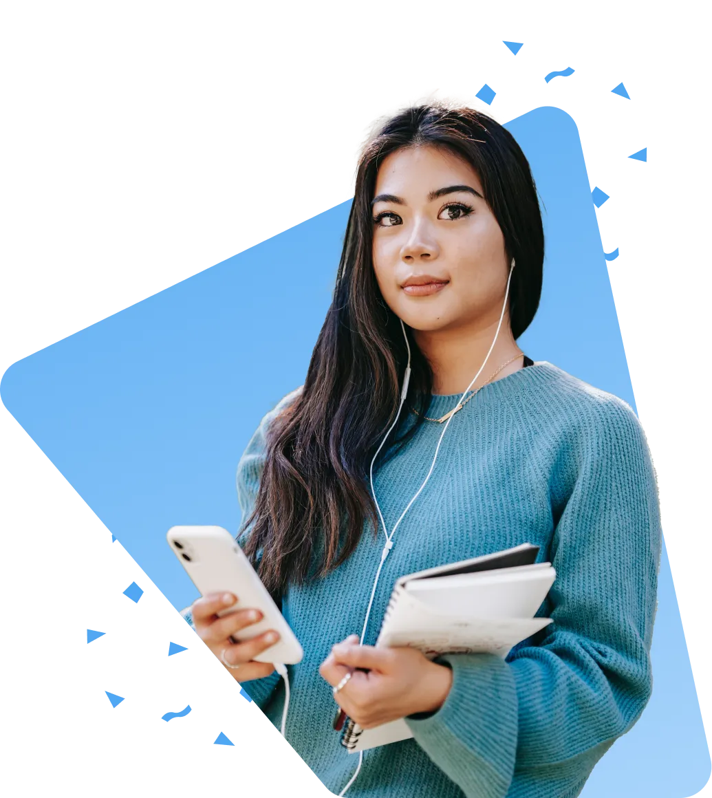 Woman with long hair in a blue sweater, holding a phone and book, earphones around her neck, and wearing a necklace.