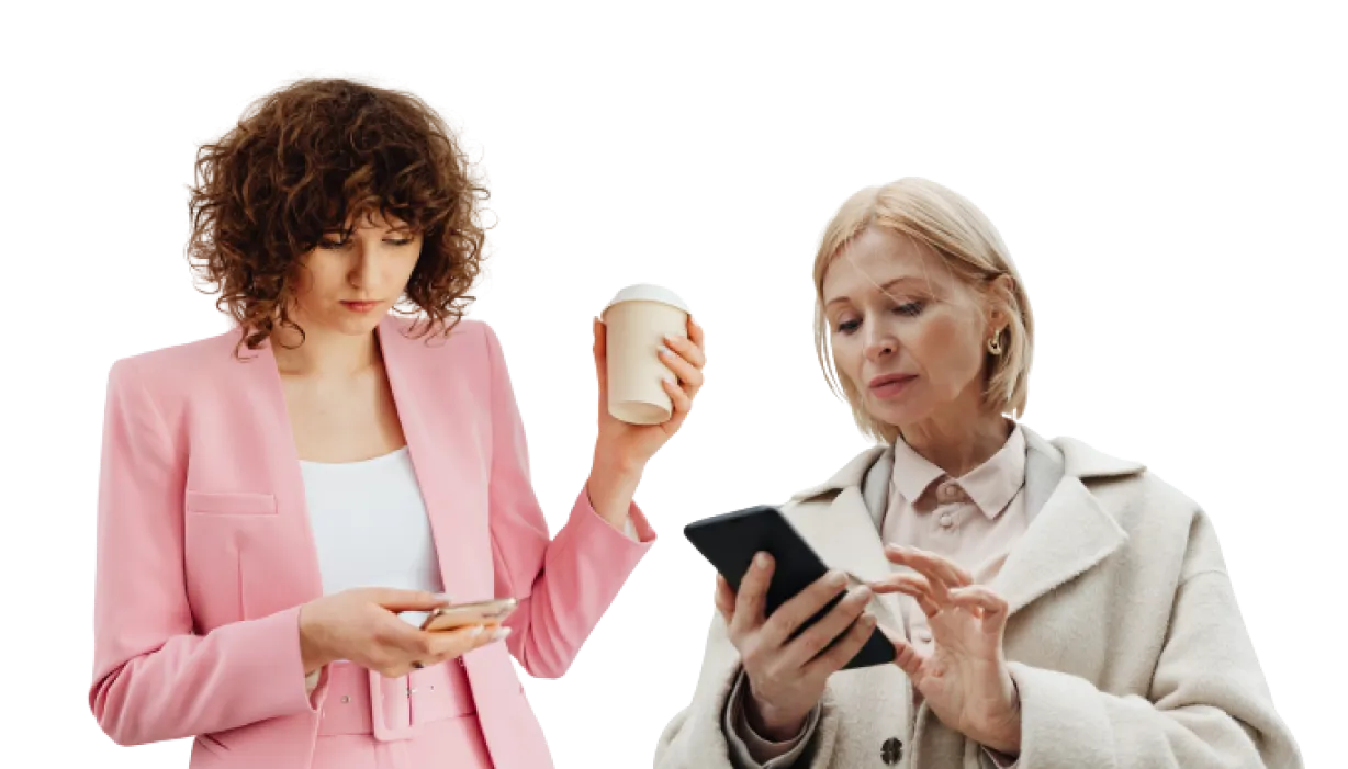 "Full shot of two women, likely in their 30s and 60s, standing side-by-side, both engaged in using their portable devices.
"