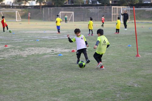 Two young students preparing to tackle each other to win possession of a football