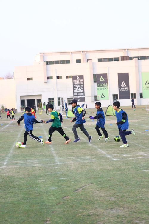 5 Young Students chasing after the football