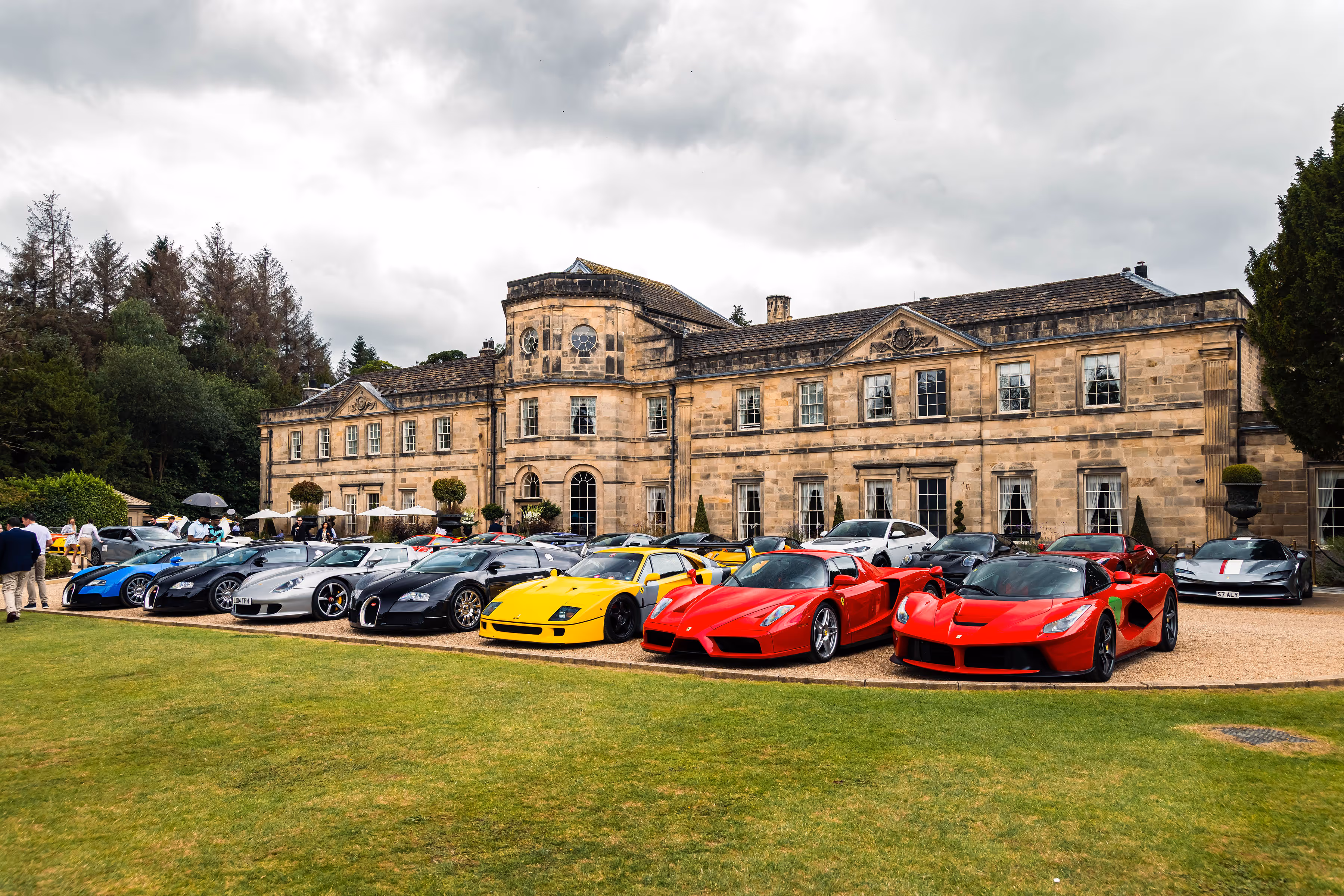A variety of exotic supercars parked in front of the historic Grantley Hall during a Supercar Driver event, showcasing the stunning vehicles and scenic backdrop.