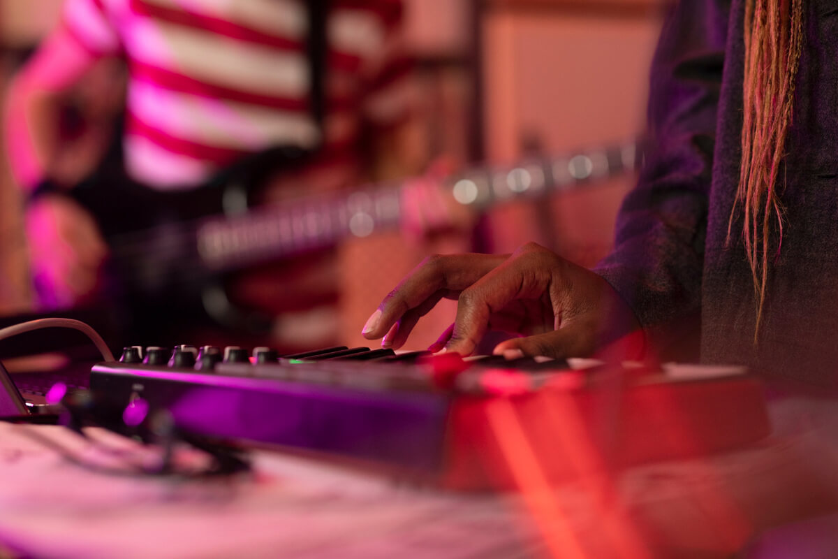 Bilde av en hånd som spiller keyboard innhyllet i rødt lys som illustrasjonsbilde for Heritage Africa Festival på Nordic Black Theatre